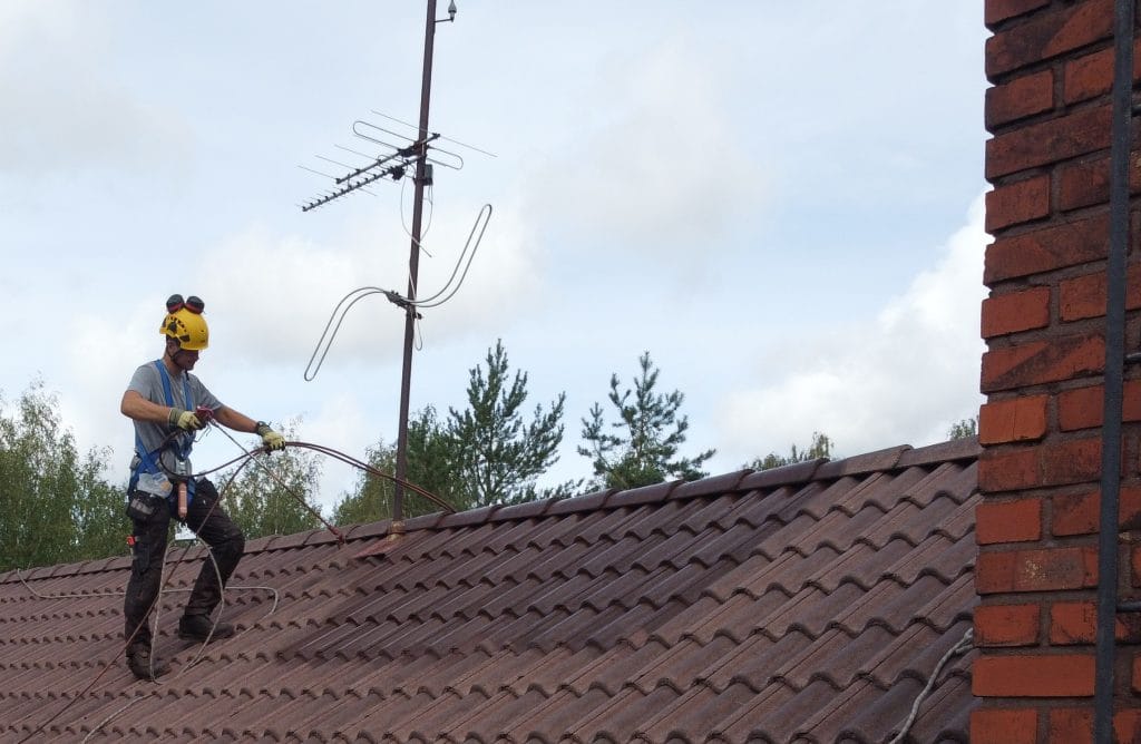 Tiilikaton pinnoituskuva. Ensimmäisen pinnoitekerroksen levitystä. Pinnoittaessa huomioitu työturvallisuus, vastuullisuus poikkeuksellisen hyvin alaan nähden.